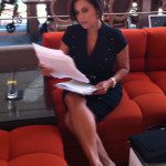A woman sitting on an orange couch.