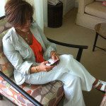 A woman sitting in a chair looking at her cell phone.