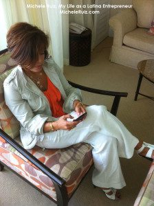 A woman sitting in a chair looking at her cell phone.