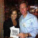 A man and woman holding a book about tribal leadership.