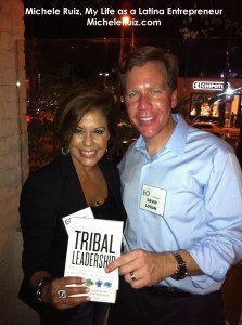 A man and woman holding a book about tribal leadership.