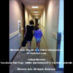 Two young girls walking down a hallway.
