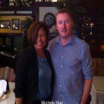 A man and woman posing for a picture in a restaurant.