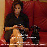 A woman sitting on a red couch with a cell phone.