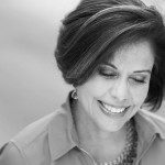 A black and white photo of a woman smiling.