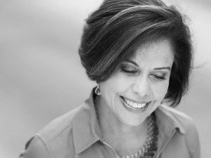 A black and white photo of a woman smiling.