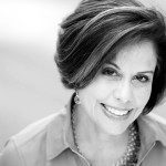 A black and white photo of a woman smiling.