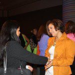 Two women shaking hands at an event.