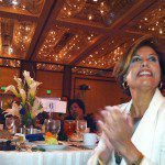 A woman clapping at a table.