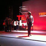 A woman standing on a stage in front of a red light.
